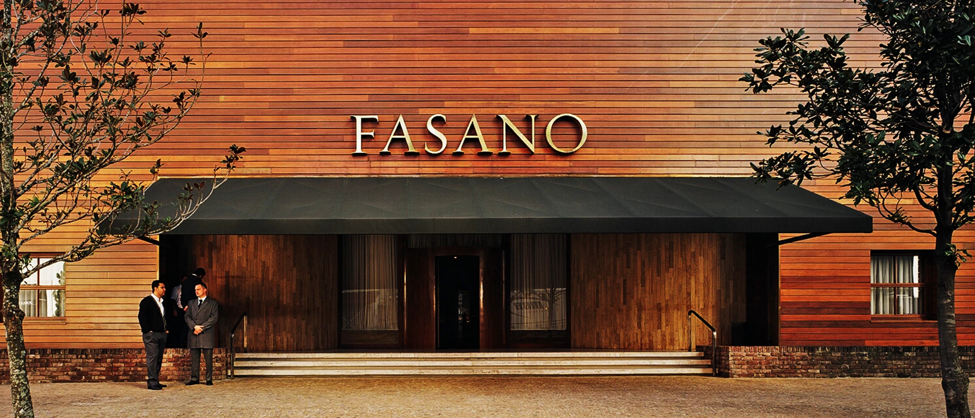 Fachada do Fasano em madeira ripada com o letreiro dourado